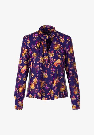 Lila Bluse mit einem floralen Muster in Orange und Gelb. Verfügt über einen gebundenen Kragen und lange Ärmel mit Knopfmanschetten. Weicher Stoff.