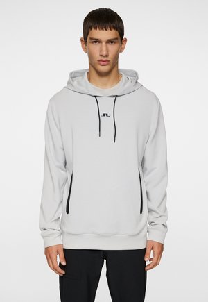 Light gray hoodie in smooth fabric, featuring black zippers, a drawstring hood, and a small logo on the chest. Long sleeves with ribbed cuffs.