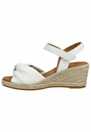 Bílý klínový sandál s pletenou podrážkou z juty, otevřenou špičkou, uzlovým předním páskem a nastavitelným páskem kolem kotníku.