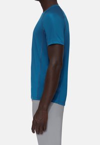 Herrarnas åtsittande blåa tränings t-shirt i fuktavvisande tyg, med korta ärmar, rund halsringning och kontrasterande sömmar.