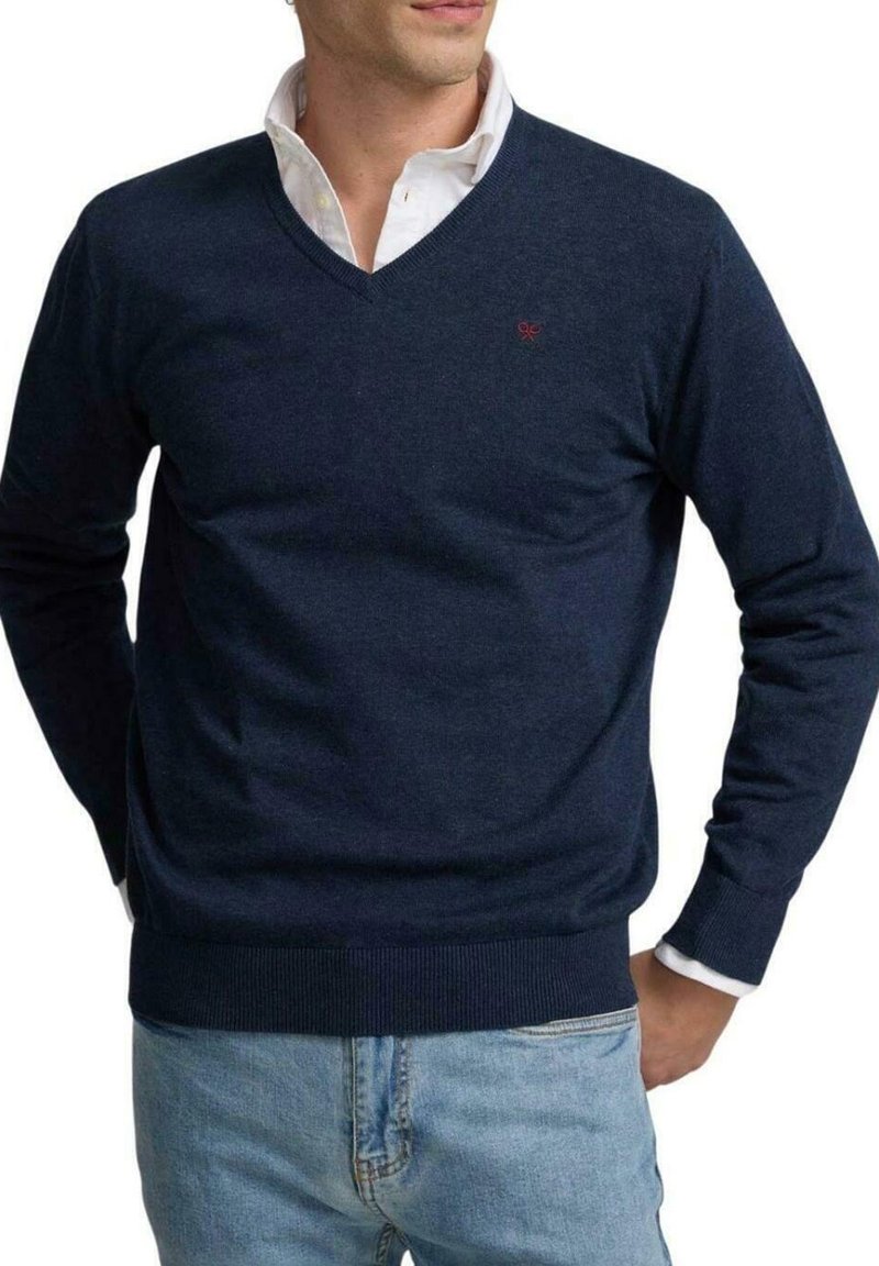 Suéter de pico en azul marino, hecho de material suave, con dobladillos y puños acanalados, y un pequeño logotipo en el pecho. Ajuste casual.