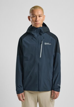 Water-resistant navy blue jacket with a hood, featuring a grey zipper pocket and black shoulder accents. Made from smooth, lightweight material.