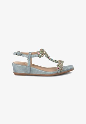 Sandalias cuña de color azul claro con un diseño de tira en T, adornadas con joyas multicolores en la parte frontal. Acabado metálico texturizado en la tira.