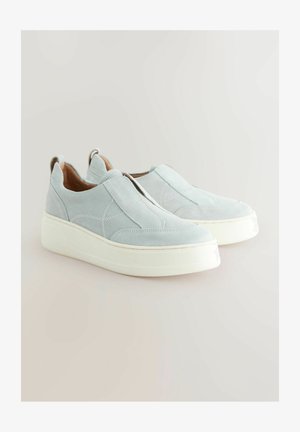 Vaaleansiniset mokkanahasta valmistetut liukupohjatossut, joissa on paksu valkoinen pohja. Tossuissa on sivusaumat ja kantapäässä vetotappi, joka helpottaa pukemista.