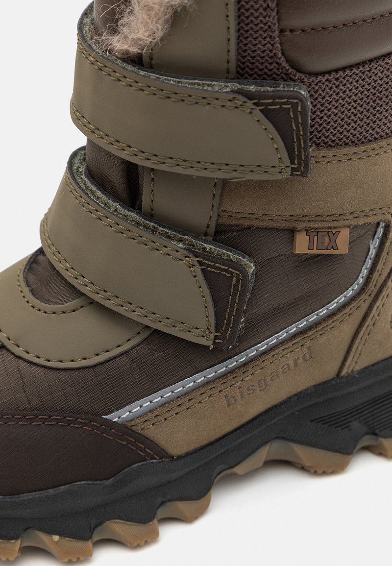 Braune und olivgrüne wasserdichte Stiefel mit Klettverschluss, strukturiertem Stoff, Gummisohle und eingeprägtem braunen Logo-Detail.