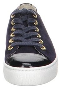 Marineblauer Canvas-Sneaker mit goldenen Ösen, flachen Schnürsenkeln und einer glänzenden schwarzen Lackzehenkappe. Weiße Gummisohle und strukturierte Details.