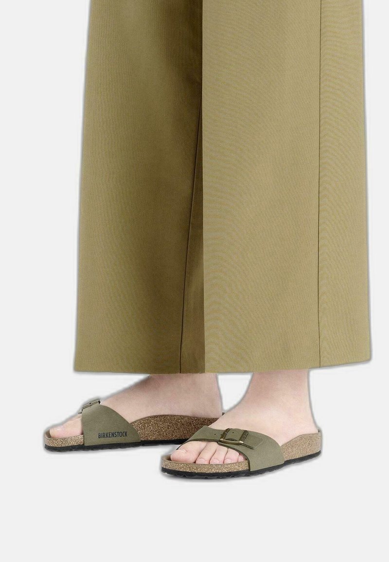 Birkenstock-sandalen in olijfgroen met een getextureerde kurken voetbed, verstelbare gespsluiting en een zacht teenvorm ontwerp.