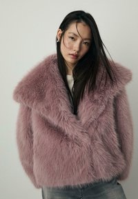 Umjetna krzna jakna u svijetloj mauve boji sa širokim ovratnikom, teksturiranom površinom i opuštenim krojem. Ima mekano, bujno tkivo i nema vidljivih kopčanja.