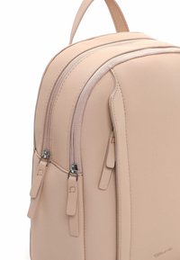 Lichtroze rugzak met een gladde textuur, voorzien van twee verticale ritsen en een synthetisch materiaal. Voorzien van dubbele ritsklemmen en een bovenste handvat.
