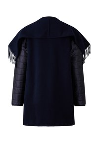 Námořnický kabát s vlněným předním dílem a prošívanými černými rukávy, má široký šálový límec s třásněmi na okrajích.