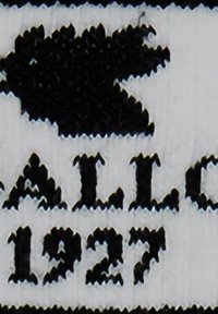 Nike Air 1972 Logo in schwarzem Stick auf weißem Stoff, mit dem ikonischen Swoosh-Design über dem Text.