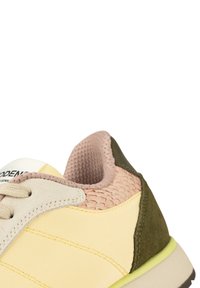 Sneaker mit einem creme-gelben Mesh-Obermaterial, leicht rosa und olivgrünen Akzenten sowie einer strukturierten Ferse. Verfügt über beiges Schnürsenkel und eine Gummisohle.