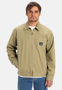 Licht olijfgroen katoenen jack met een rits aan de voorkant, kraag en een borstzak met een logo-label. Lange mouwen en een ontspannen pasvorm.