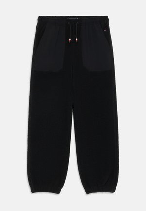 Schwarze Fleece-Jogginghosen mit elastischem Bund, zwei Fronttaschen und Rippbündchen. Mit kontrastierenden schwarzen Taschenpanelen.