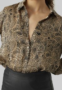 Chemise à boutons en tissu léger avec un motif cachemire marron et noir, dotée d'un col pointu et d'une coupe décontractée.