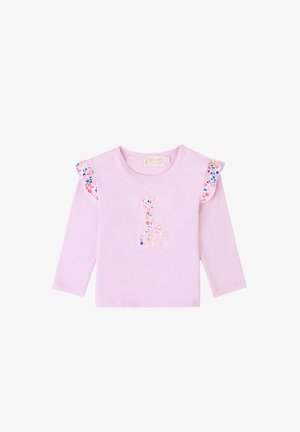 Camicia a maniche lunghe di un rosa chiaro con volant a fantasia floreale e un'applicazione di un giraffe colorato al centro della parte anteriore. Il tessuto sembra morbido e liscio.