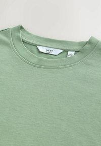 Grøn afslappet pasform bomulds t-shirt med synlig NEXT mærke og størrelse L mærker, lagt fladt på en hvid overflade.