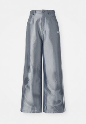 Pantalons à jambes larges en matériau gris brillant, présentant des bandes latérales blanches et un motif de flammes sur les jambes inférieures. Fermeture à bouton et à zip à la taille.