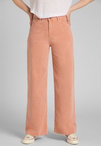 Jeans de pierna ancha, de color durazno, fabricados con un tejido suave, que cuentan con una cintura alta, un diseño clásico de cinco bolsillos y acentos de costura mínimos.