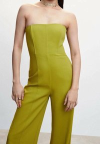 Šaty bez ramínek v jasně zelené barvě, strukturovaný design, bezešvý korzet, široké nohavice, texturovaná tkanina, doplněné metalickou náhrdelníkem.