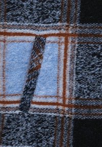Tela de lana a cuadros en tonos azul, negro y marrón. El diseño incluye cuadrados y un acabado texturizado para mayor calidez.