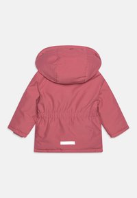 Veste imperméable rose pâle avec capuche, taille élastique et manches longues. Comprend un accent réfléchissant blanc à l'arrière.