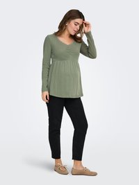 Long-sleeve, ribbed maternity top in muted green with a V-neck and lace trim; paired with black slim-fit pants and tan ballet flats.