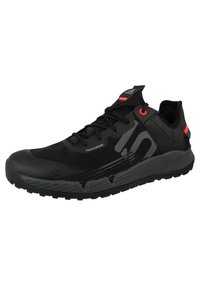 Czarne buty sportowe wykonane z siateczkowych i syntetycznych materiałów, z teksturowaną podeszwą, czerwonymi akcentami oraz smukłym, nowoczesnym designem.