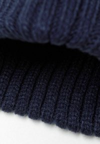 Rippstrickstoff in einem tiefen Marineblau, der eine weiche Textur mit vertikalen Mustern und einem leichten Glanz zeigt.