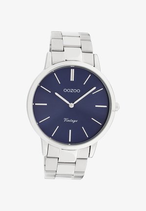 Montre-bracelet en métal argenté avec cadran bleu, marqueurs horaires minimalistes, logo OOZOO et texte "Vintage" sur le cadran.