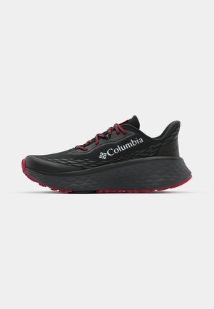 Chaussure de sport noire avec tige texturée, lacets rouges et logo. Semelle épaisse avec motif de la semelle pour une meilleure adhérence. Design minimaliste, vue de côté.