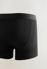 Schwarze Baumwoll-Boxershorts mit einem weichen Bund. Sie verfügen über ein elegantes Design und eine glatte Textur mit dezenten Nähdetails.