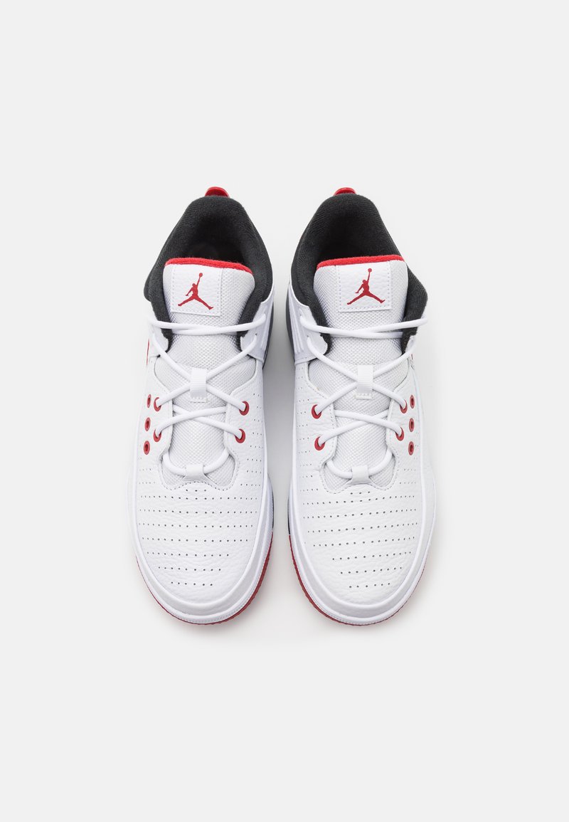Zapatillas deportivas con una parte superior sintética blanca, acentos rojos, textura perforada, interior negro y un distintivo logo de Jumpman en la lengüeta.