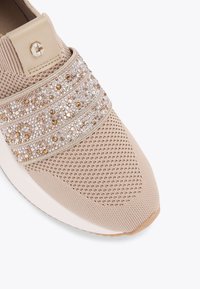 Sneaker beige con tomaia in rete testurizzata, fasce decorative di perline in oro e argento, e suola bianca solida. Design della punta arrotondata.