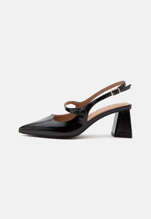 Chaussure slingback en cuir verni noir avec bout pointu, bride à bouton sur le cou-de-pied et talon bloc incliné vers l’extérieur.