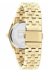 Gold stainless steel wristwatch with a woven strap, round face, and a silver back featuring the brand name "TOMMY HILFIGER."