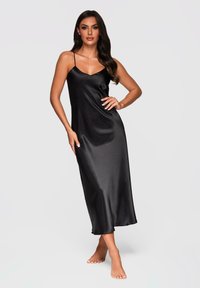 Vestido maxi de satén negro con tirantes finos, textura suave y silueta ajustada, con escote en v y diseño hasta los tobillos.