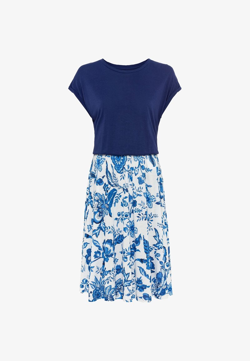 Haut bleu marine à manches courtes avec un col rond associé à une jupe blanche à imprimé floral dans des teintes de bleu, présentant un design évasé.