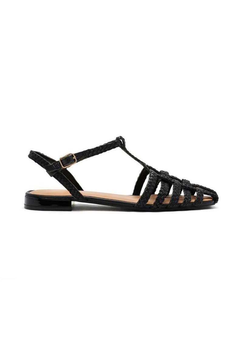 Sandal de tiras trenzadas negras con diseño de T-strap, suela plana y un acabado brillante negro en el talón. Presenta punta abierta y textura tejida.