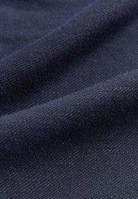 Dunkelblauer Stoff mit feiner Webstruktur, der eine glatte, leicht glänzende Oberfläche und gleichmäßige Farbe aufweist.