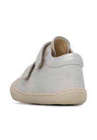 Scarpa in pelle argentata con una texture morbida, dotata di una fascia in velcro e suola in gomma con battistrada pattern per una buona aderenza.