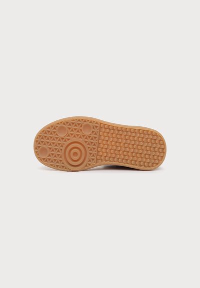 Semelle de chaussure en caoutchouc beige clair avec des motifs de semelle circulaires à la pointe et au talon, et un motif en grille rectangulaire au médio-pied et à l'avant-pied.
