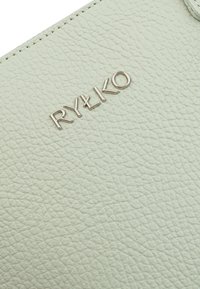 Portafoglio in pelle testurizzata verde chiaro con logo "RYŁKO" in argento embossato. Superficie liscia con dettagli a grana fine.
