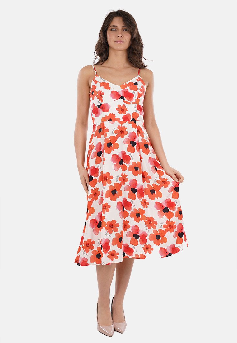 Abito midi floreale con spalline sottili, caratterizzato da una base bianca e audaci fantasie di fiori rossi e neri. Gonna fluida, tessuto morbido.