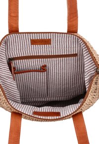 Geweven rieten handtas interieur met beige stof met bruine en witte strepen, een ritsvak en lichtbruine leren accenten.