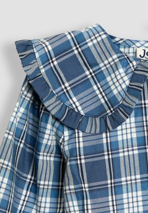 Kék kockás blúz, fodros gallérral, sötétkék, világoskék és fehér csíkok mintáival az anyagon. Texturált pamut alapanyag.