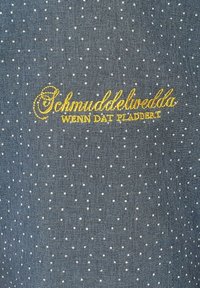 Tessuto grigio con pois bianchi e testo ricamato in oro "Schmuddelwedda WENN DAT PLADDERT." Texture liscia, design casual.