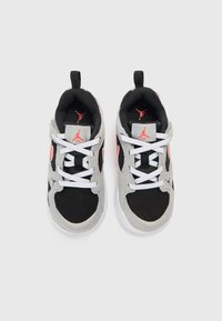 Αθλητικά παπούτσια με μαύρο επάνω μέρος από δί χτυ, γκρι σουέντ λεπτομέρειες και λευκά κορδόνια. Διαθέτουν κόκκινο λογότυπο στο πλάι και ταινία έλξης στη φτέρνα.