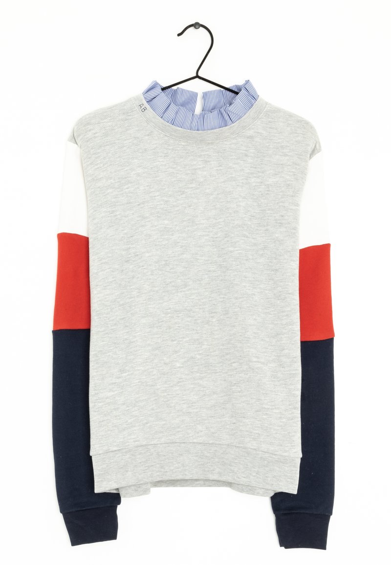 Sudadera gris con un cuello de rayas azul y blanco con volantes, cuenta con mangas en rojo, blanco y marino. Hecha de una tela suave con un corte relajado.