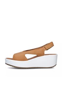 Sandalo con zeppa in pelle marrone, con punta aperta e design a tagli laterali. Presenta un suola platform bianca e una tracolla regolabile.